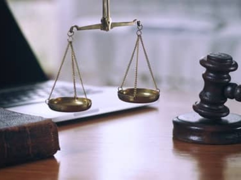 Law composition with scale and gavel on old brown leather book