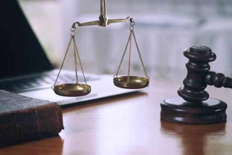 Law composition with scale and gavel on old brown leather book