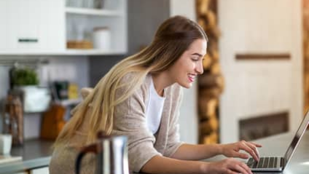 Young woman using her laptop at home