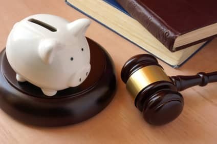 Piggy bank, gavel and books on a table.