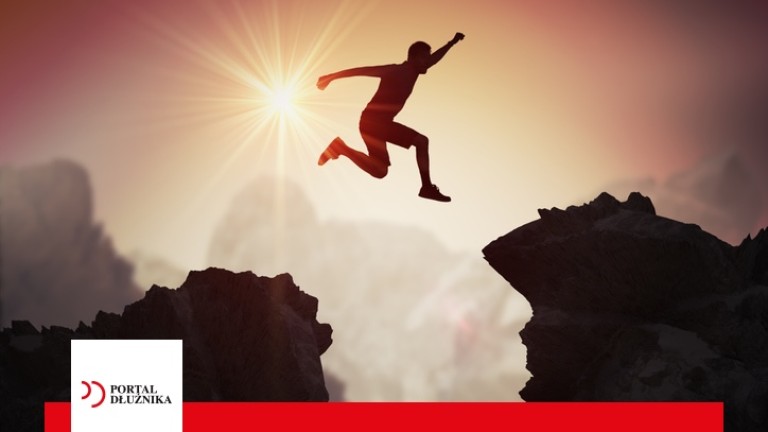Silhouette of young man jumping over mountains and cliffs at sunset.