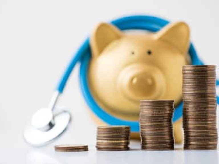 piggy bank with stethoscope and coins stack on white background