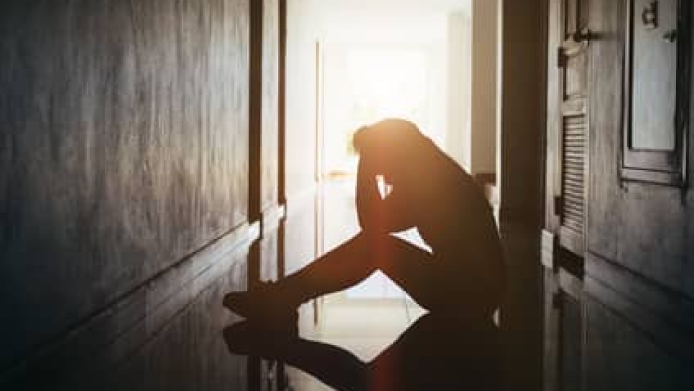Silhouette of sad and depressed women sitting at walkway of condominium or office with backlit and lens flare,sad mood,feel tired, lonely and unhappy.Vintage style.
