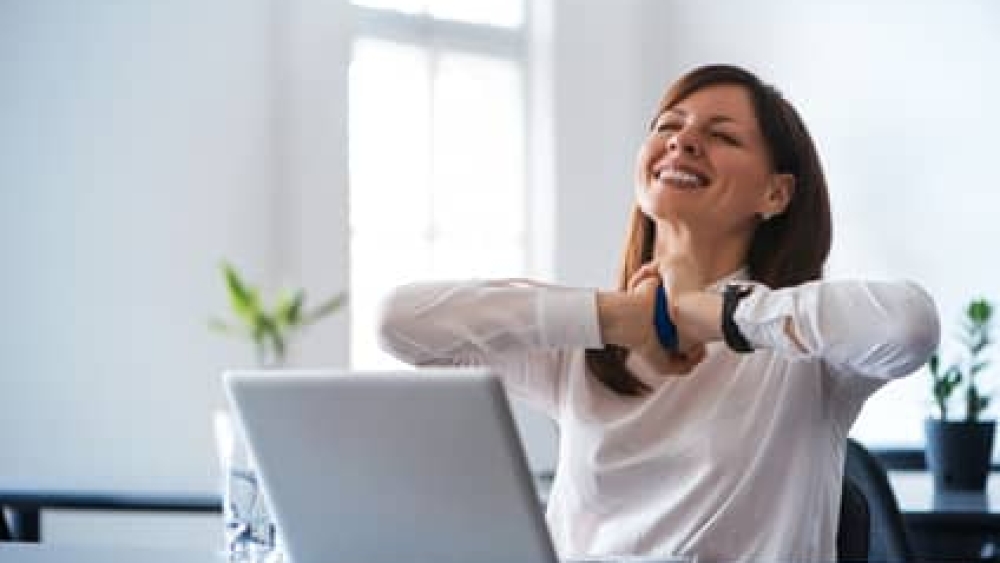 Excited woman working at desk in office. Using antistress ball.