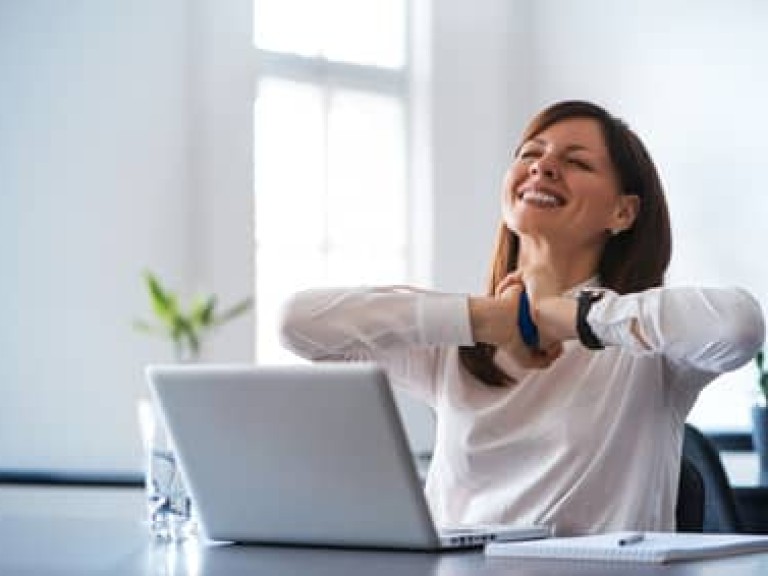 Excited woman working at desk in office. Using antistress ball.