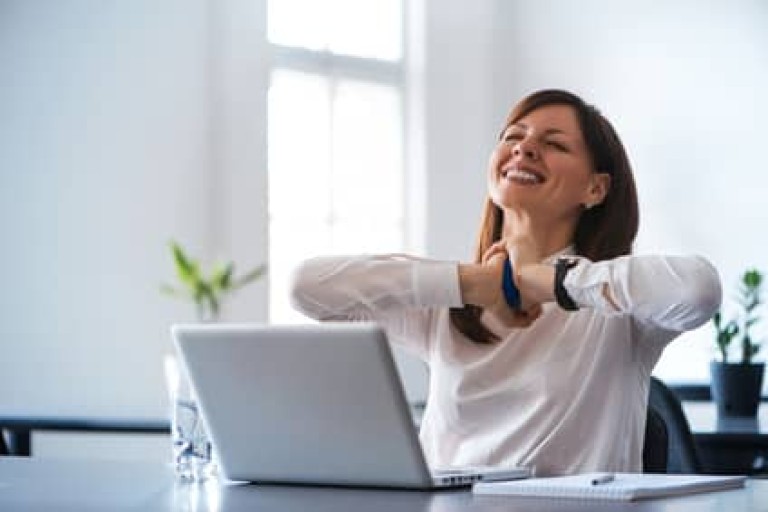 Excited woman working at desk in office. Using antistress ball.