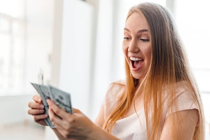 Blonde long-haired woman counting money at home