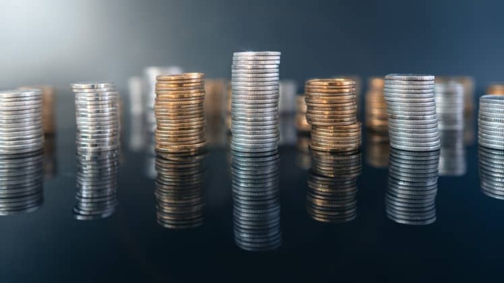 Piles of coins (polish zloty, grosze, PLN) on a black, reflective surface. Inflation consuming our savings. Difficult economy situation in Poland.