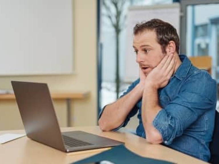 Surprised man looking at laptop screen