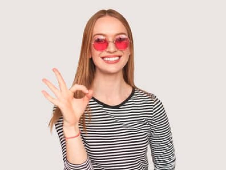 Trendy girl showing OK gesture on white