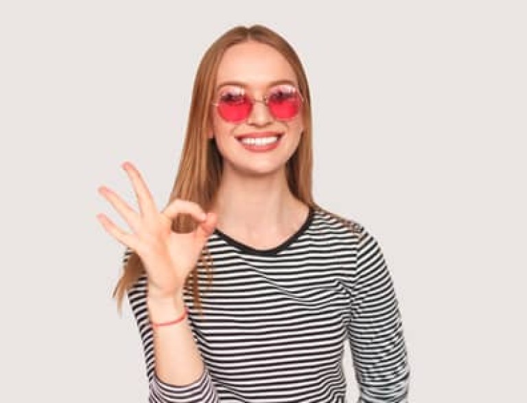 Trendy girl showing OK gesture on white